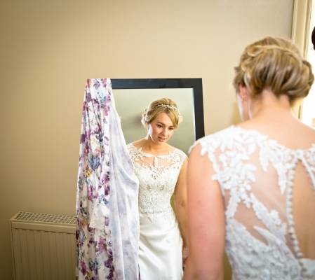 Bride looks in the mirror.